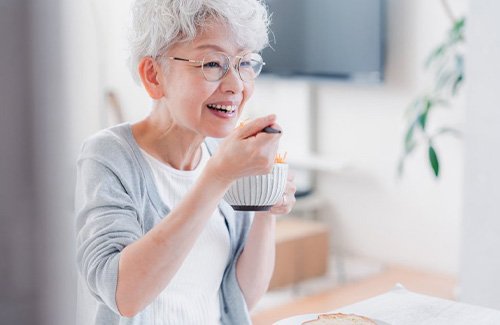 Woman enjoying breakfast in her kitchen