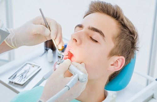 A man having his tooth examined by a dentist
