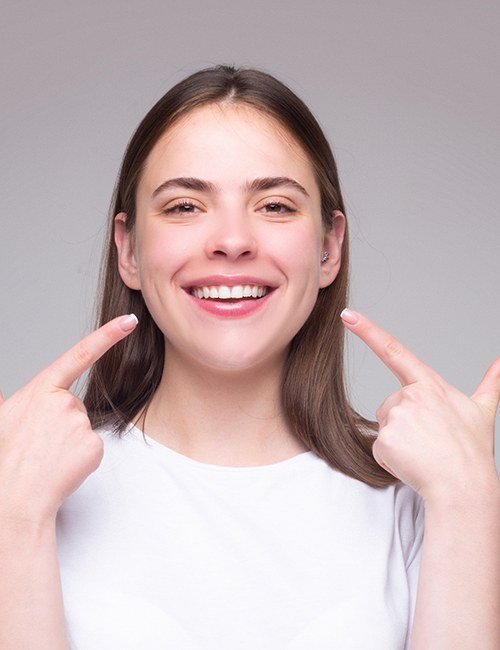 a patient pointing to her white smile