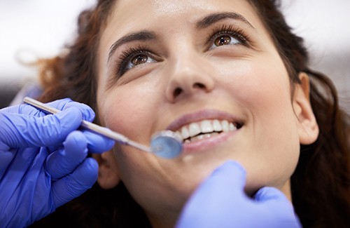 a patient smiling after paying cost of emergency dentistry