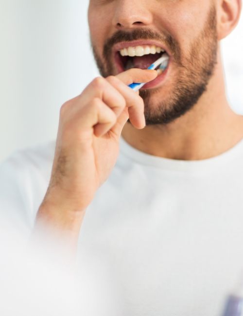 Man brushing teeth to prevent dental emergencies