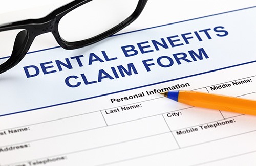Black-framed glasses on a dental benefits claim form