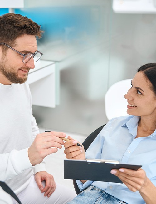 Woman filling out paperwork about the cost of teeth whitening in Taylor